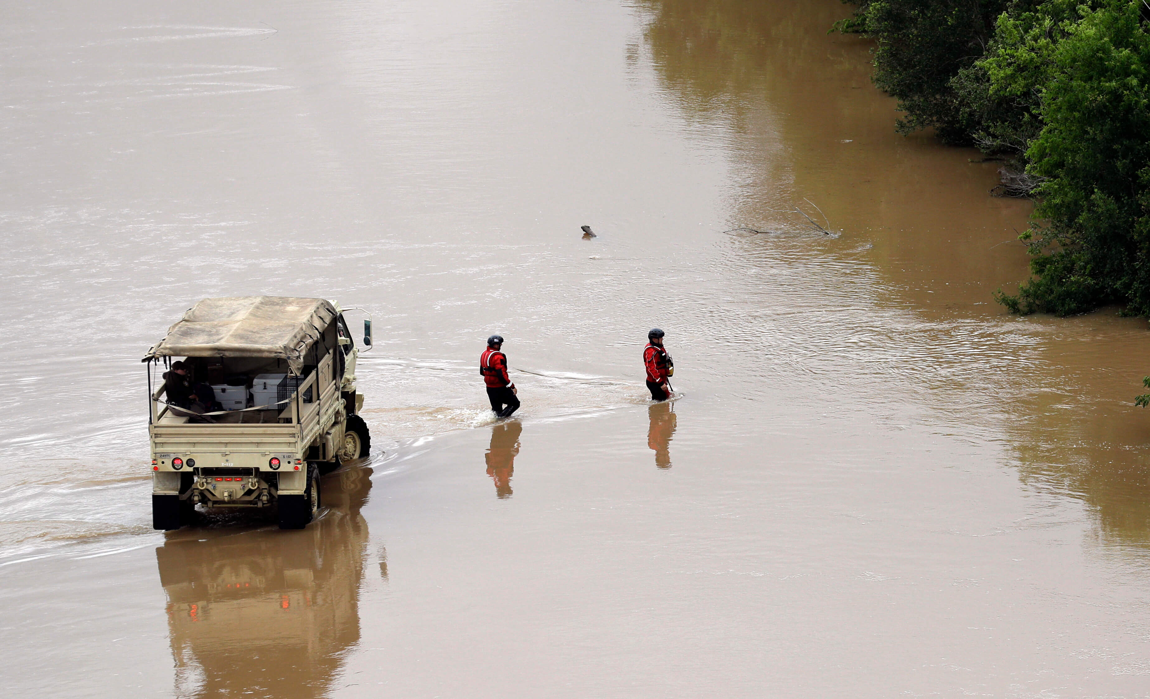 street in Texas flooded with car and two people