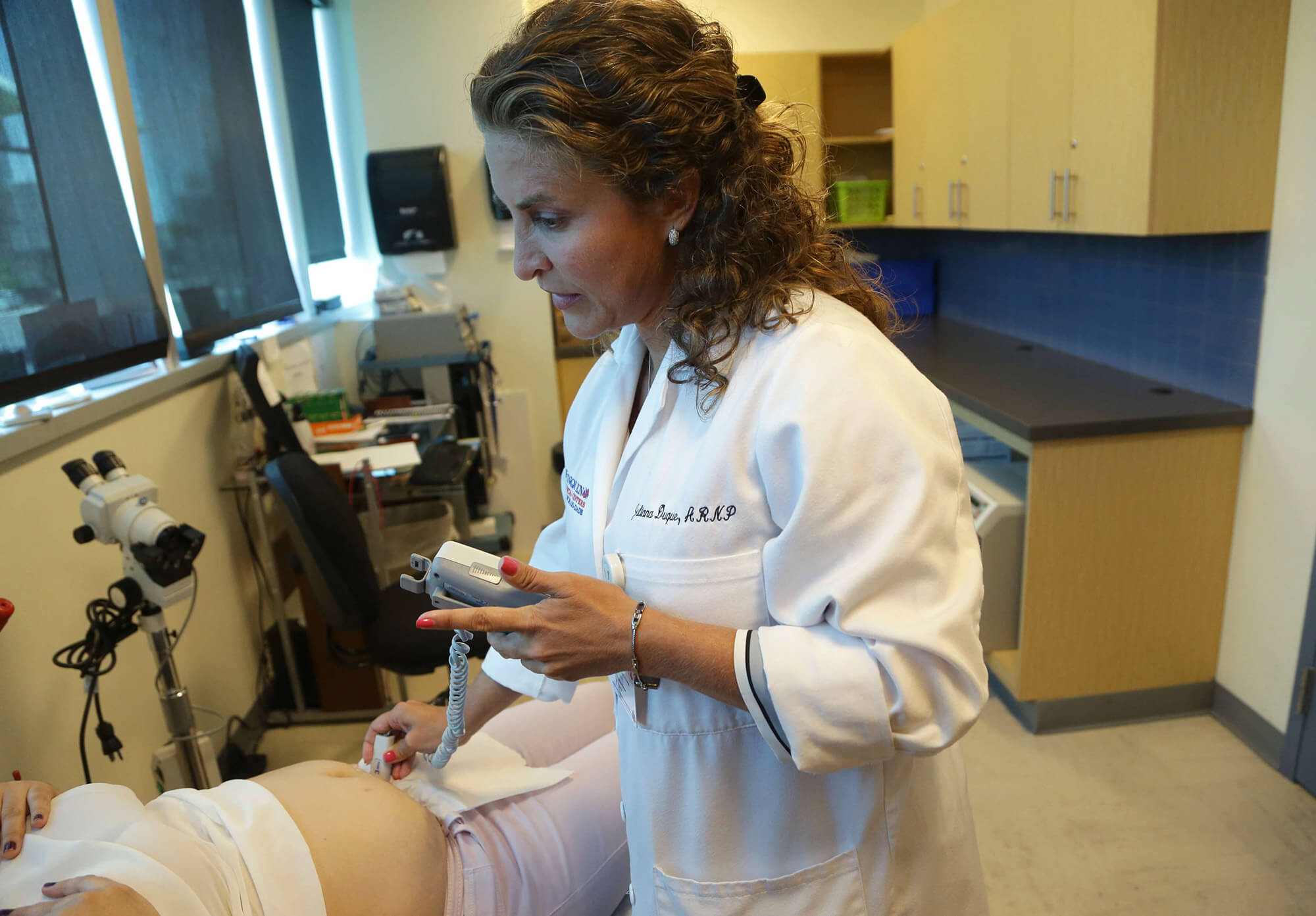 Doctor helping pregnant patient in Florida