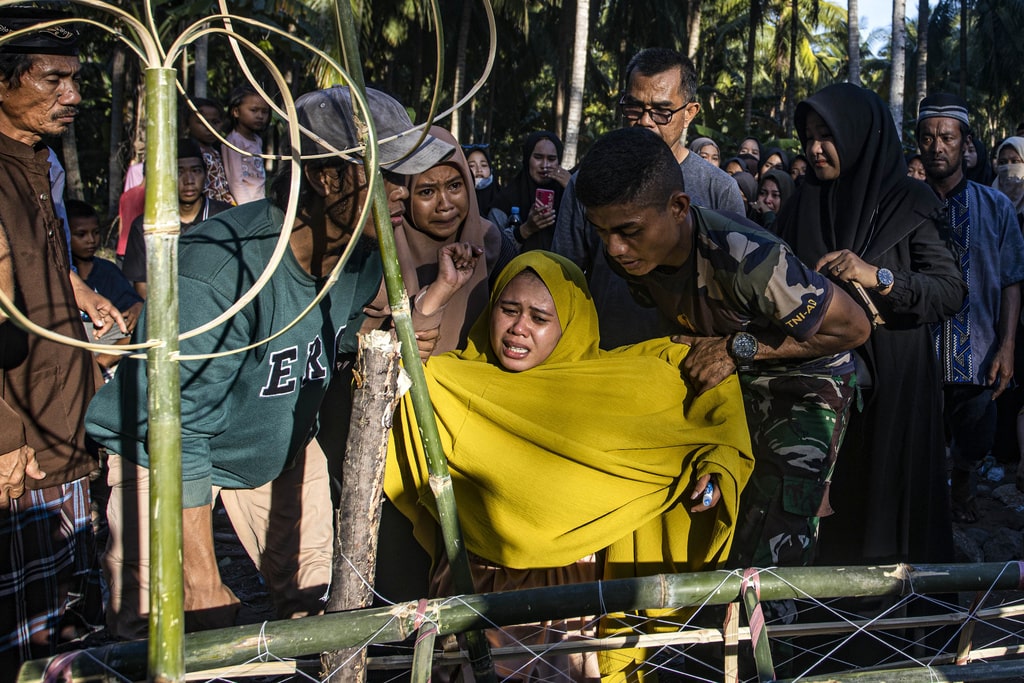 Relatives weep during the funeral of Irfan Bukhari, one of the victims of the explosion of a smelting furnace at a Chinese-owned nickel plant on Indonesia's Sulawesi island, at a cemetery in Polewali Mandar, Indonesia, Tuesday, Dec. 26, 2023.