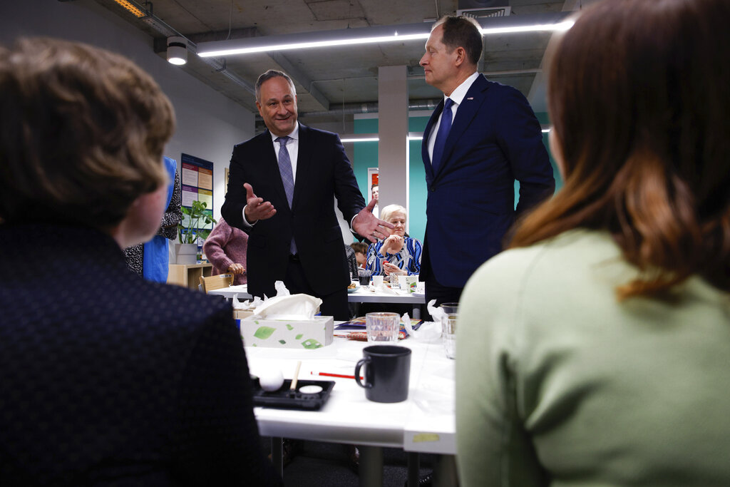 U.S. Second Gentleman, Douglas Emhoff, left, and US Ambassador to Poland, Mark Brzezinski, right, speak with Ukrainian refugees at the UNHCR Community Center in Krakow, Poland, Saturday, Jan. 28, 2023