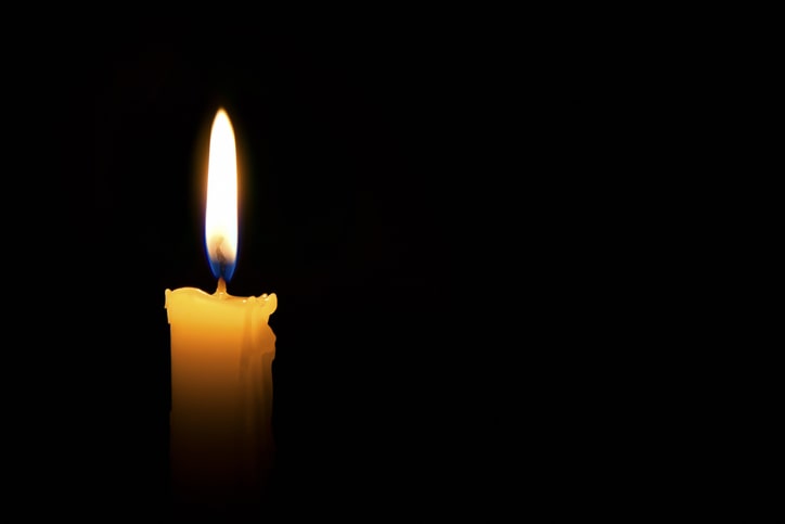 Single lit candle with flame