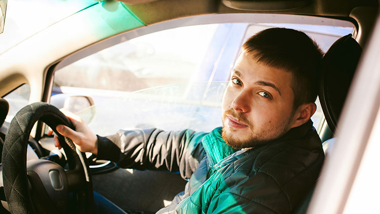 A young male driver in a car