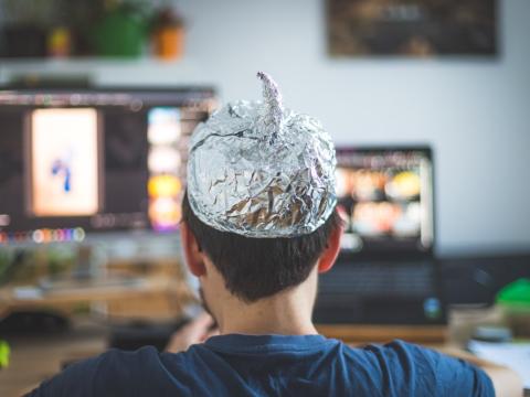 Man in a tinfoil hat sitting down