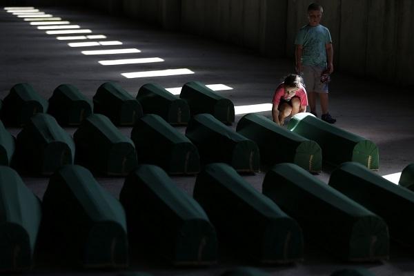 Bosnian children view the coffins of Srebrenica victims.